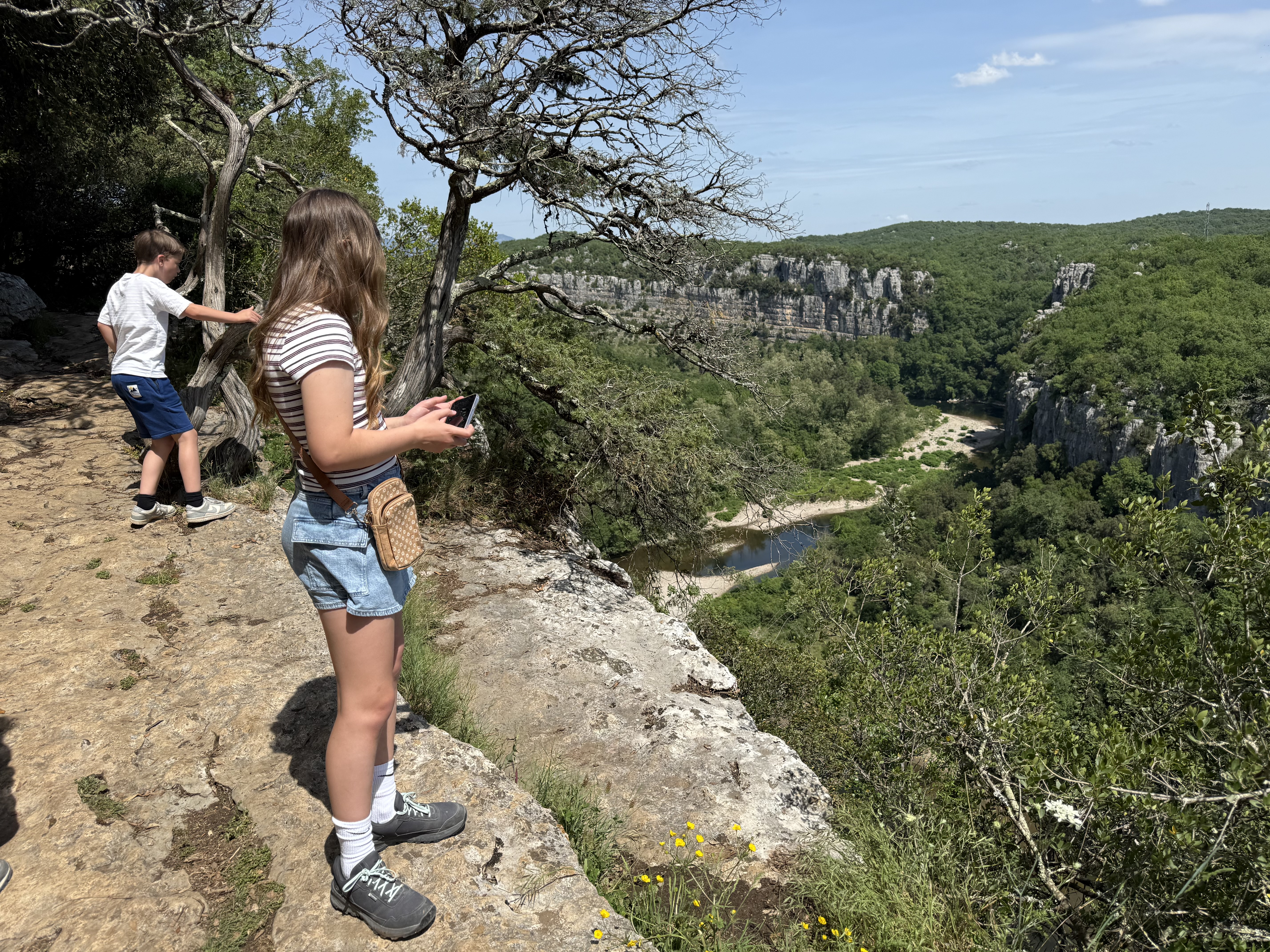 Twee kinderen bij het uitzichtpunt aan de rand van de canyon in het Bois de Païolive